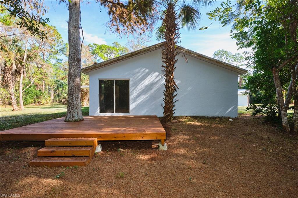Back of property with a deck and stucco siding