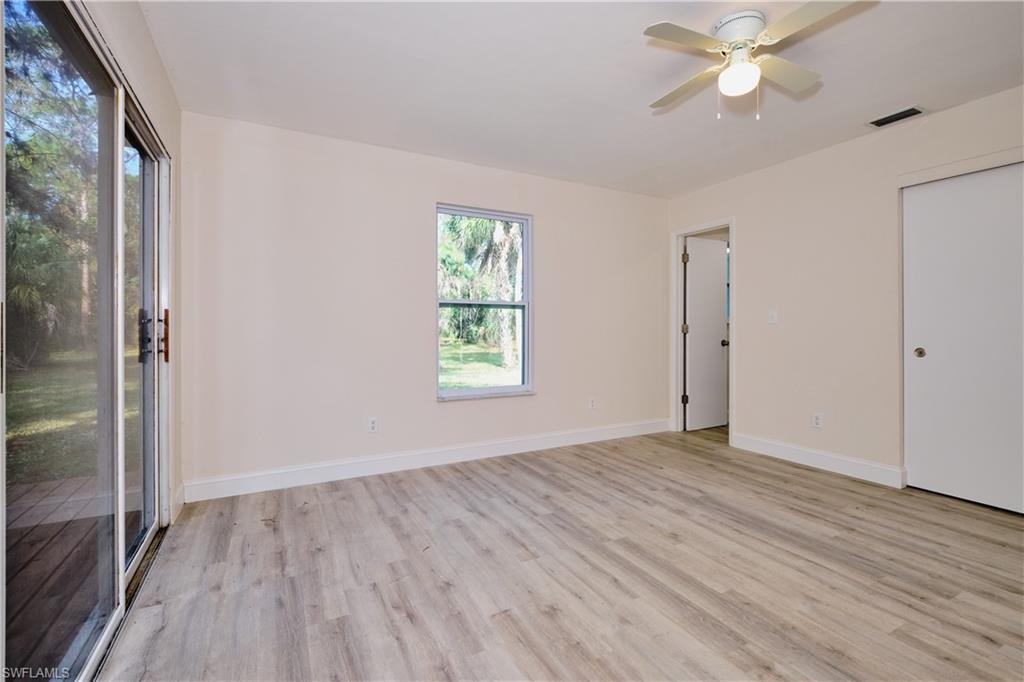 Unfurnished bedroom with access to outside, ceiling fan, and light wood-style flooring