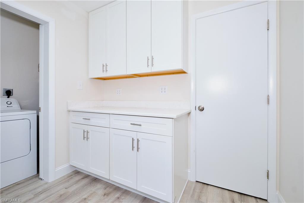 Laundry area featuring washer / clothes dryer and light wood finished floors