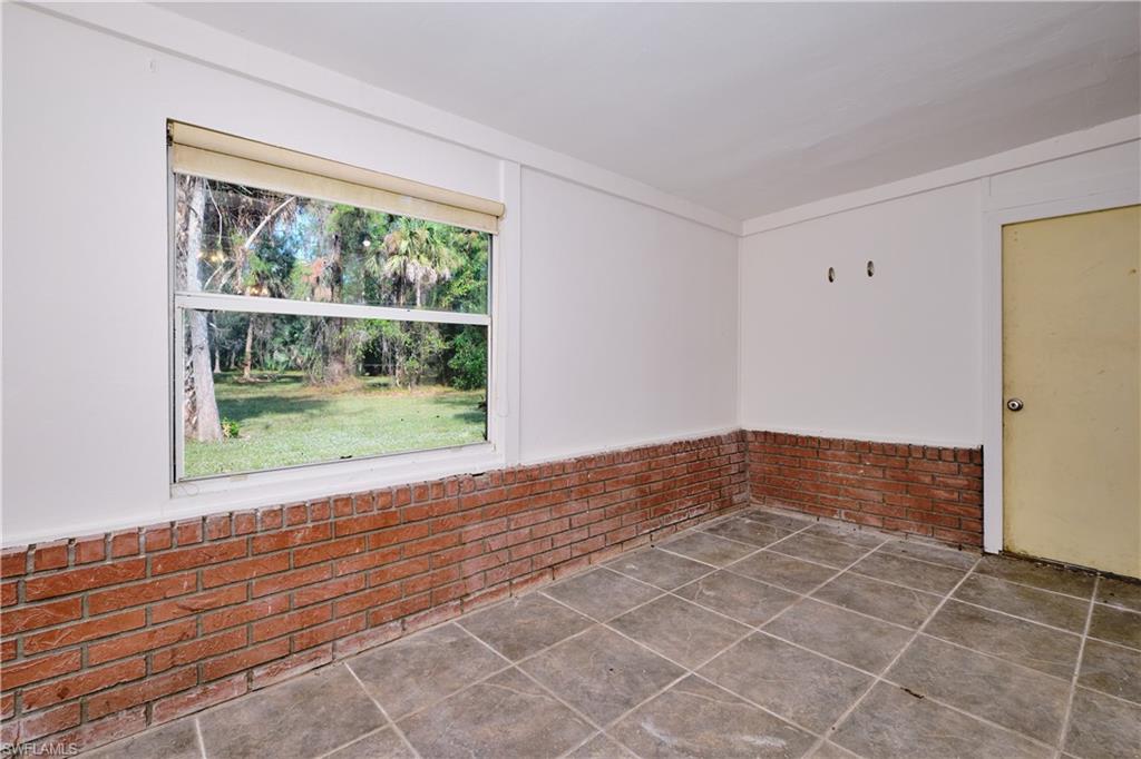 Spare room with brick wall and wainscoting