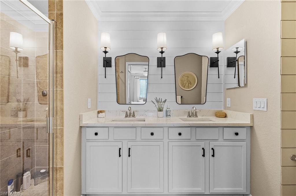 Bathroom with vanity, an enclosed shower, and ornamental molding
