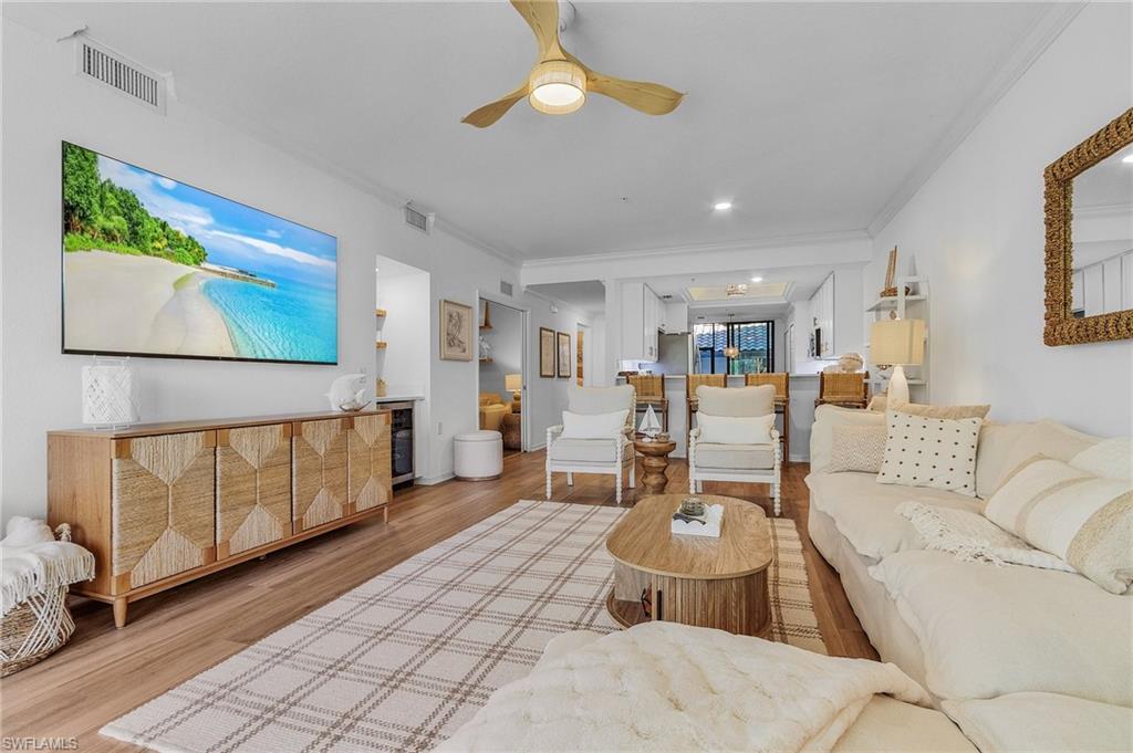 Living room featuring wine cooler, ceiling fan, wood-type flooring, and ornamental molding