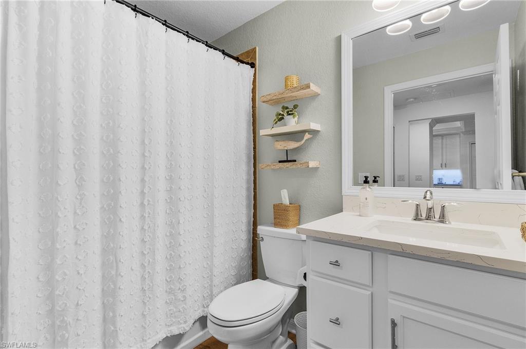 Guest bathroom with shower over tub.