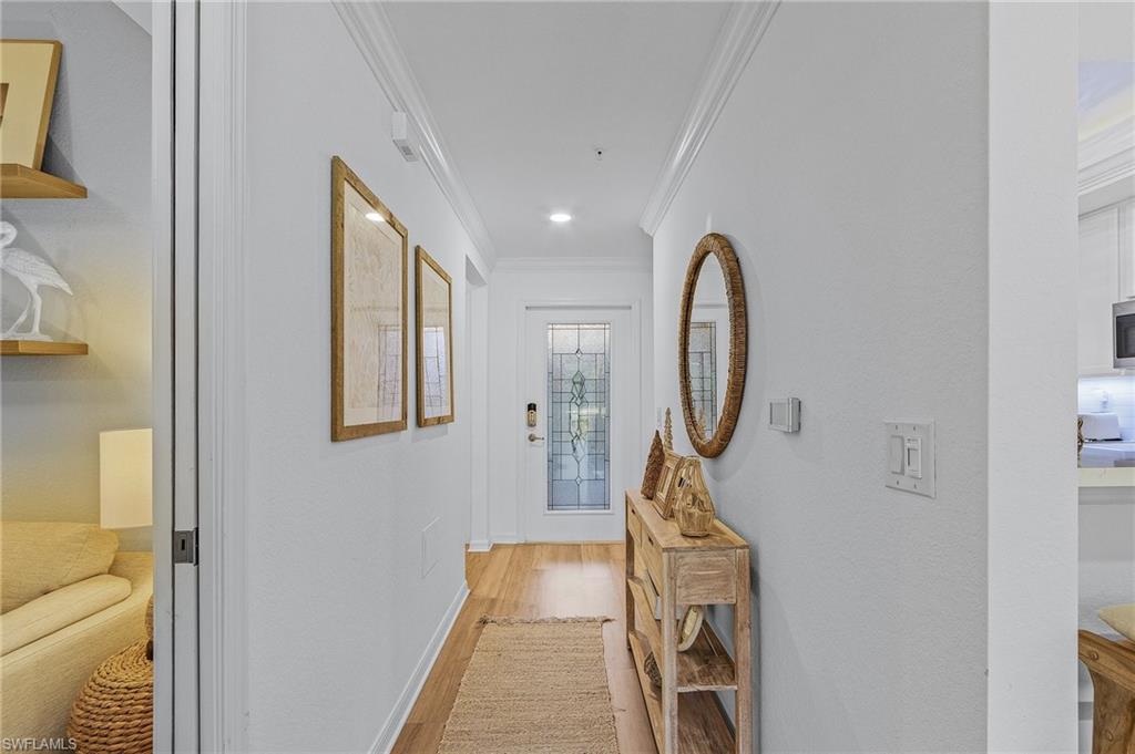 Hall featuring light hardwood / wood-style flooring and crown molding