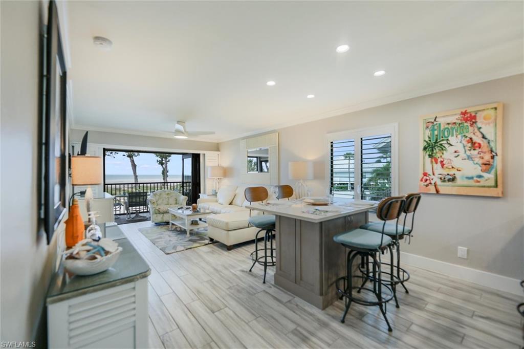 Living room with crown molding, recessed lighting, plenty of natural light, and light wood-style floors
