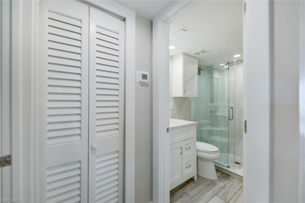 Full bathroom with a closet, vanity, a stall shower, and recessed lighting