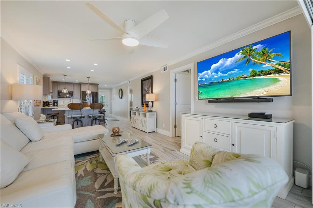 Living area featuring ornamental molding, light wood-type flooring, a ceiling fan, and recessed lighting