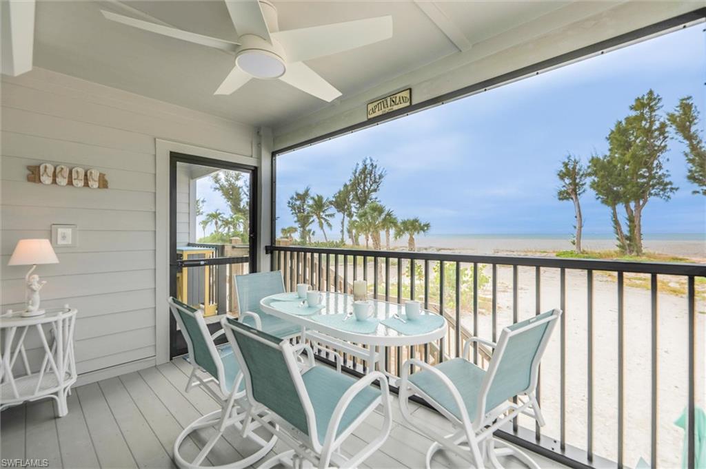 Sunroom / solarium featuring view of water and beach