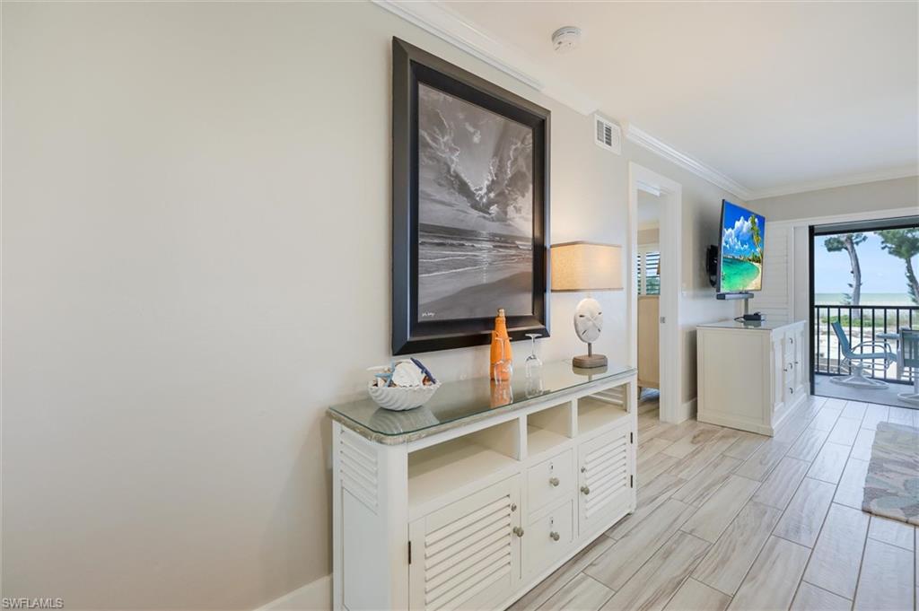Hallway featuring crown molding and wood tiled floors