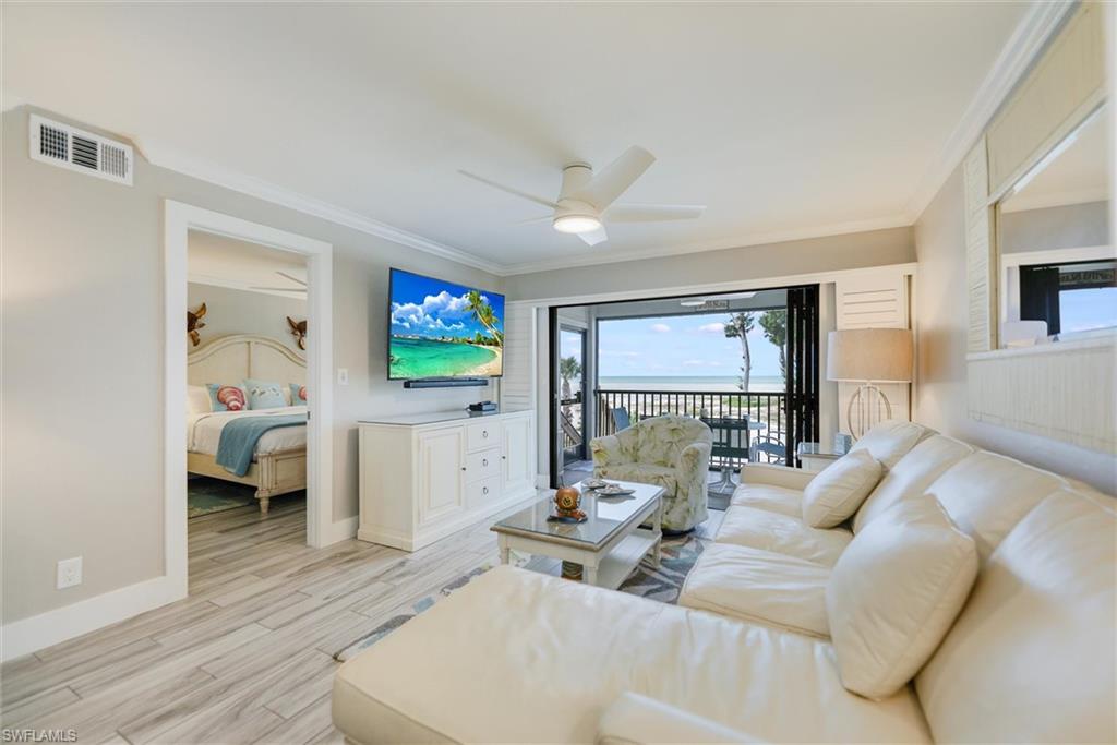 Living area with ornamental molding, wood finish floors, and ceiling fan