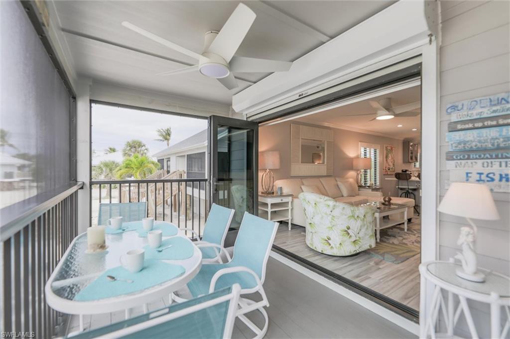 Sunroom / solarium with a balcony, ceiling fan, healthy amount of natural light, and outdoor dining space