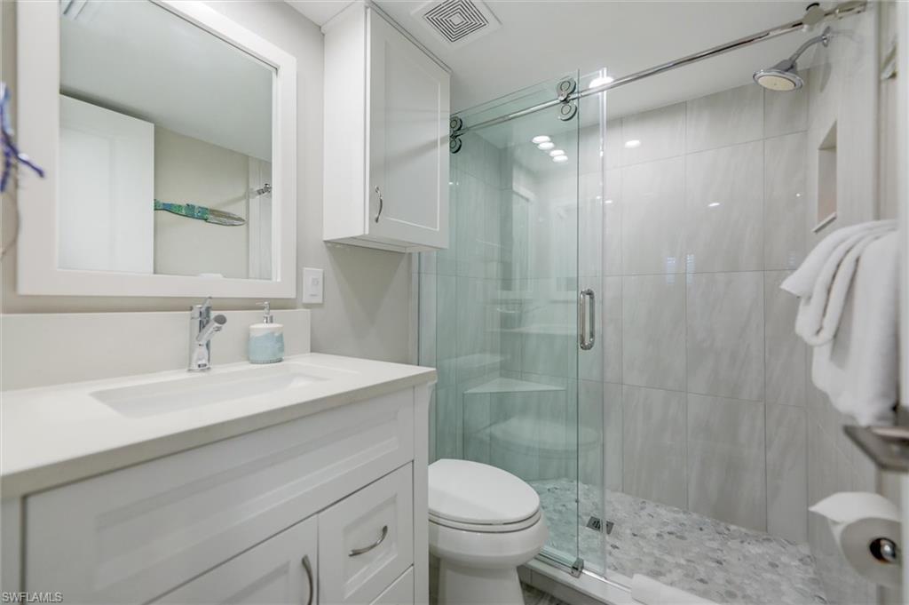 Full bathroom with vanity and a shower stall