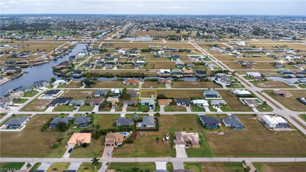 Aerial view of property and surrounding area featuring nearby suburban area and a nearby body of water