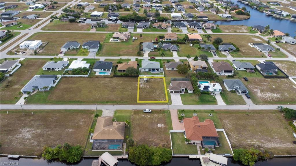 Aerial view of property and surrounding area featuring nearby suburban area and property boundaries highlighted