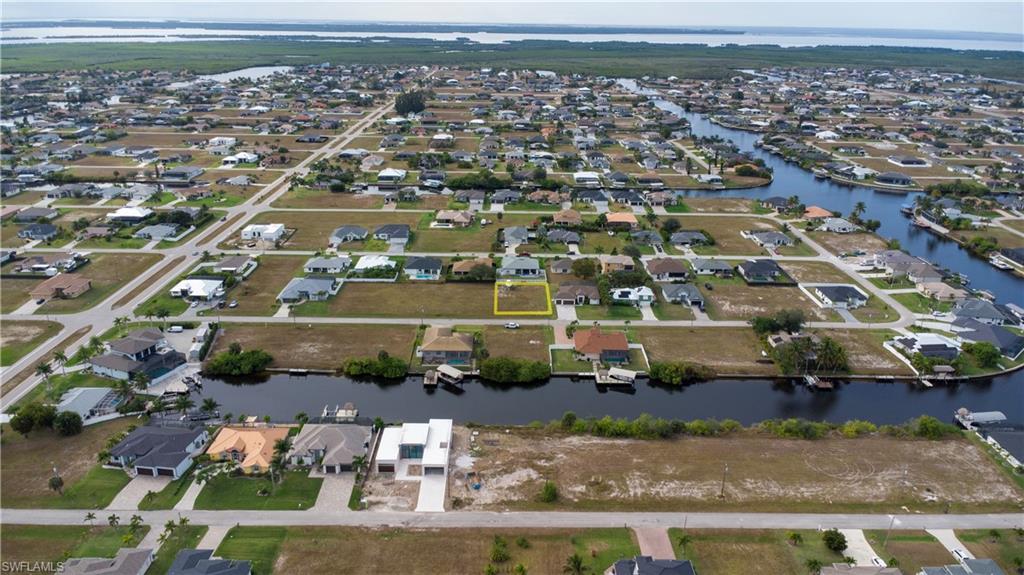Aerial view of property and surrounding area with nearby suburban area and a large body of water