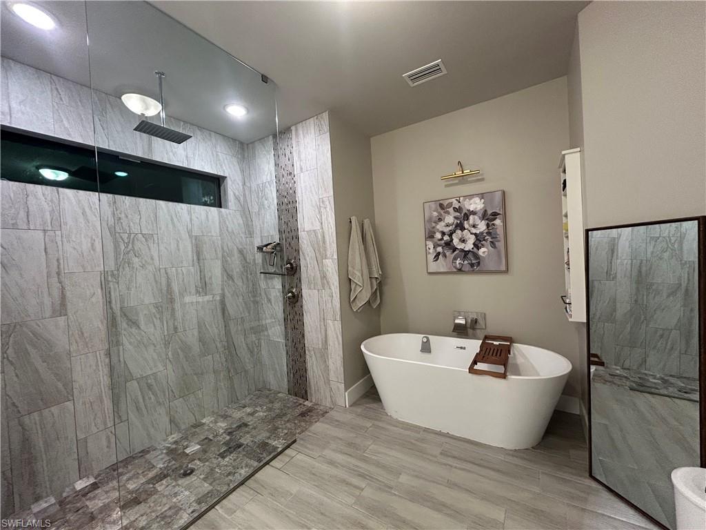 Bathroom with a walk in shower and a freestanding bath
