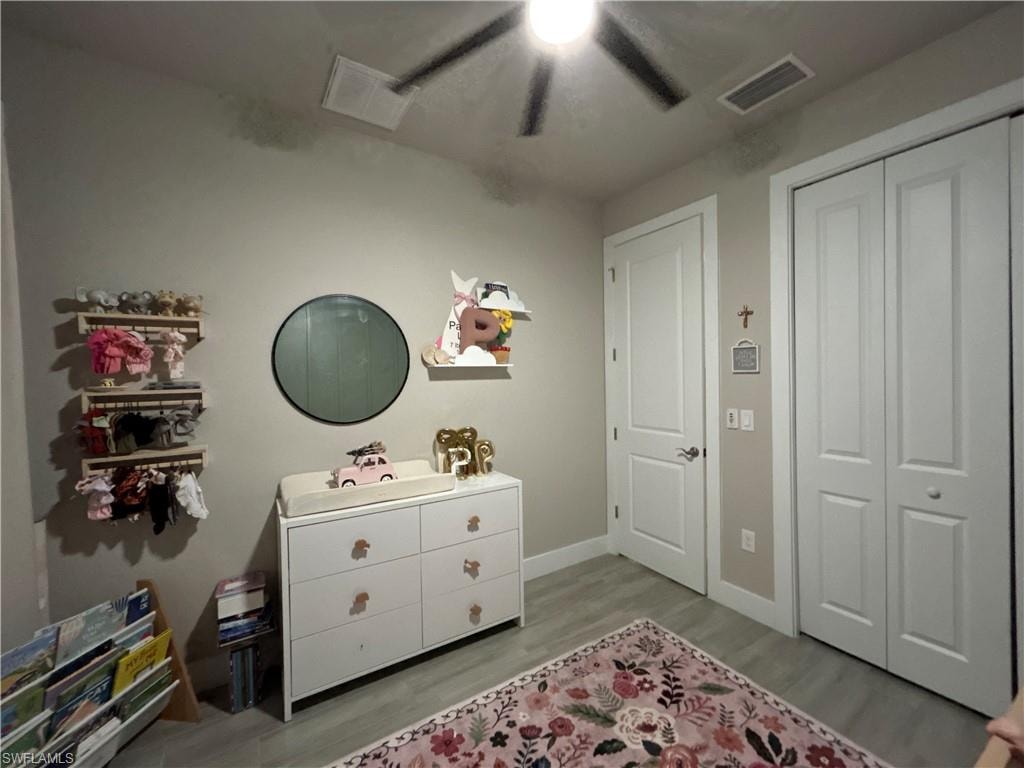 Bedroom featuring ceiling fan, light wood-style flooring, and a closet