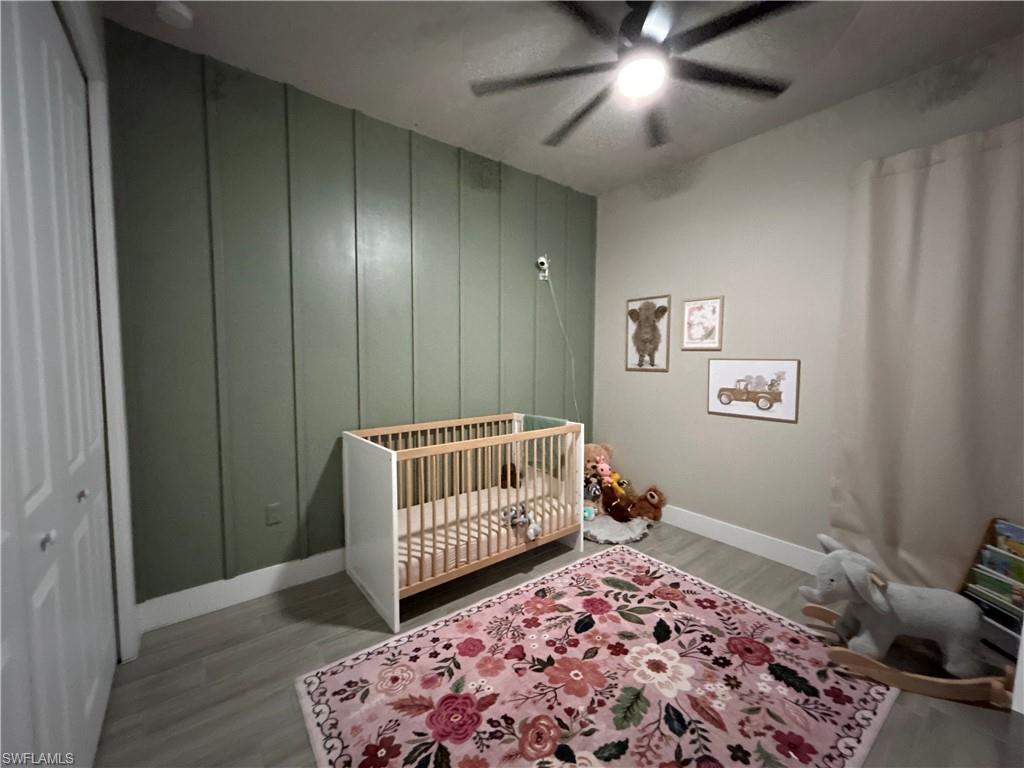 Bedroom with ceiling fan, and a decorative wall