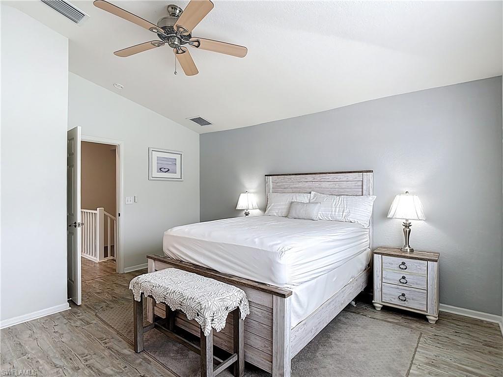 Bedroom with vaulted ceiling, ceiling fan, and light wood-style flooring