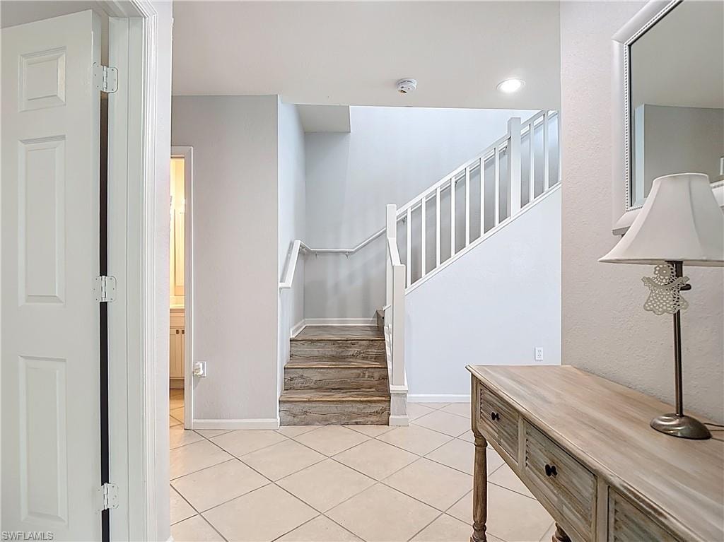 Stairway with tile patterned floors and recessed lighting