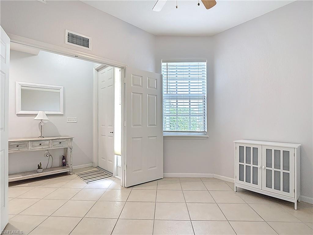 Foyer entrance with a ceiling fan and light tile patterned flooring