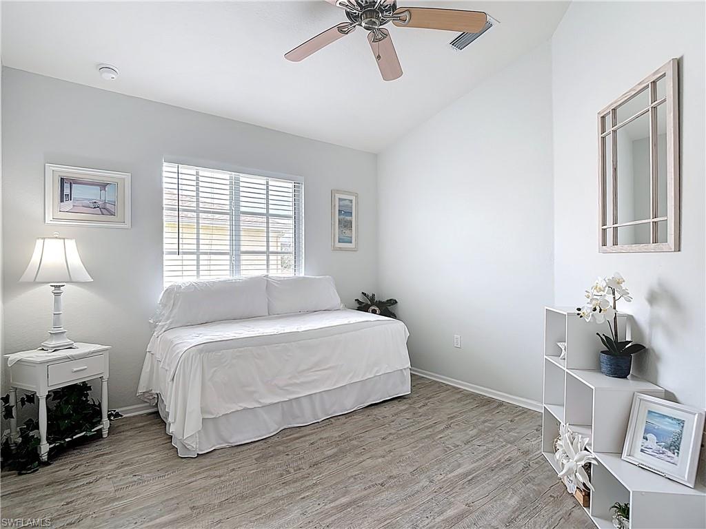 Bedroom featuring light wood finished floors, ceiling fan, and vaulted ceiling