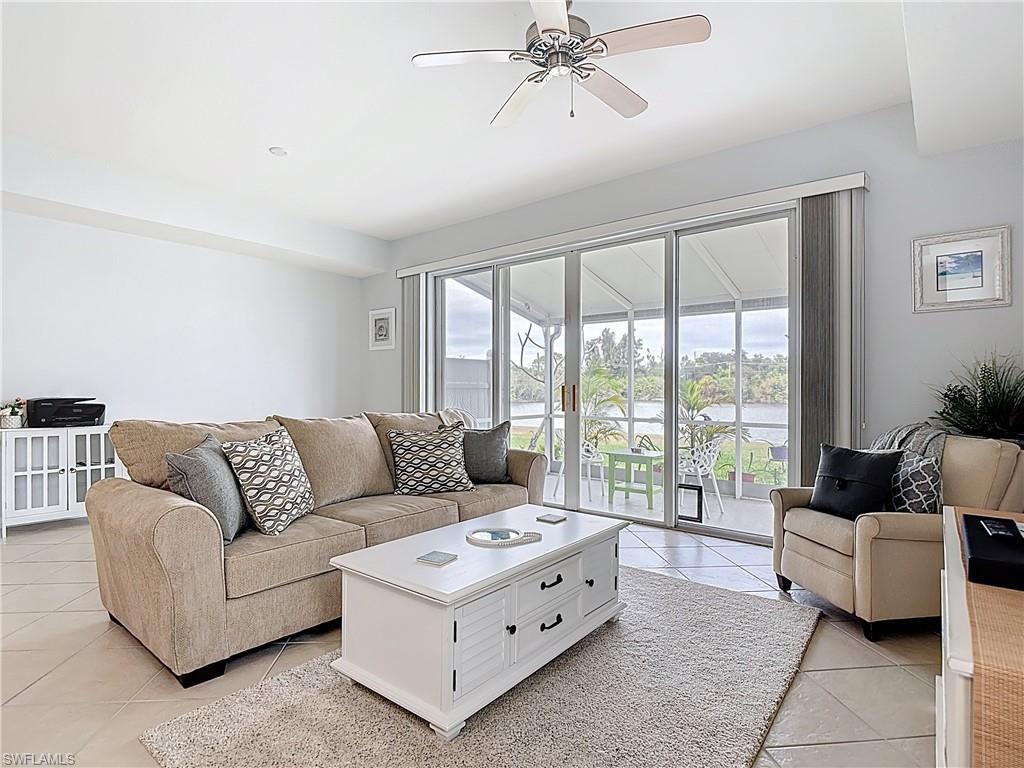 Living room with ceiling fan and light tile patterned floors