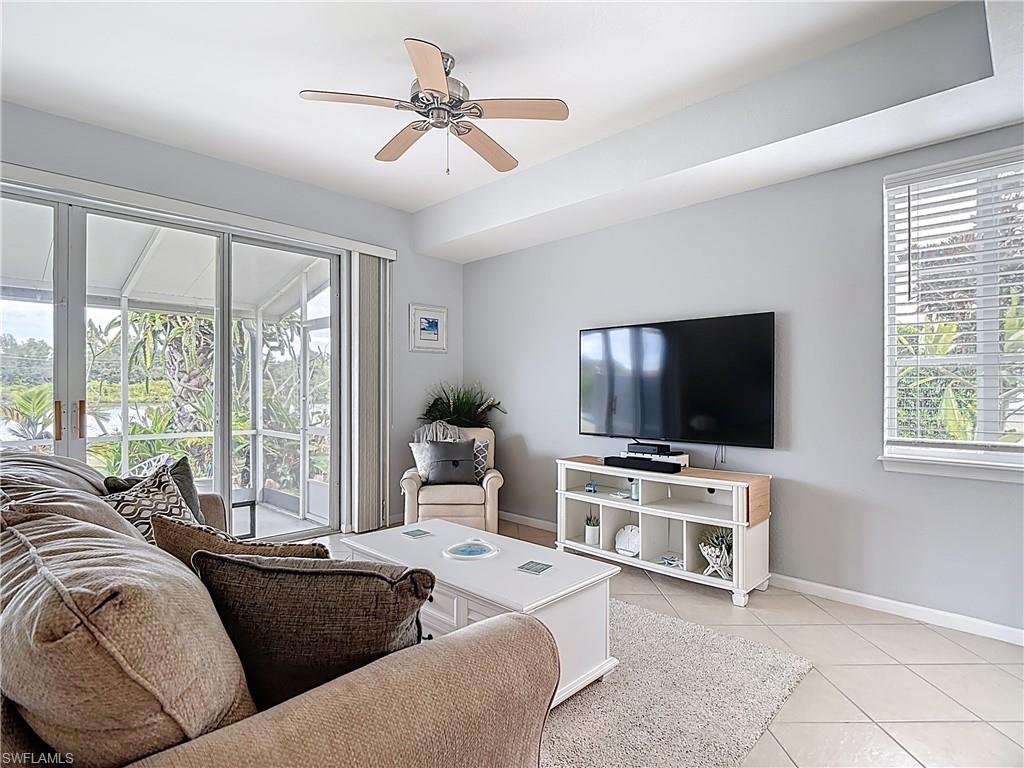 Living room with ceiling fan and light tile patterned flooring