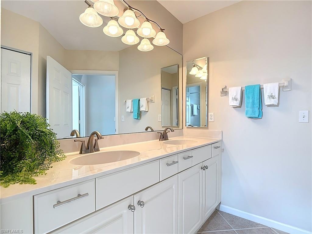 Bathroom featuring double vanity and light tile patterned floors