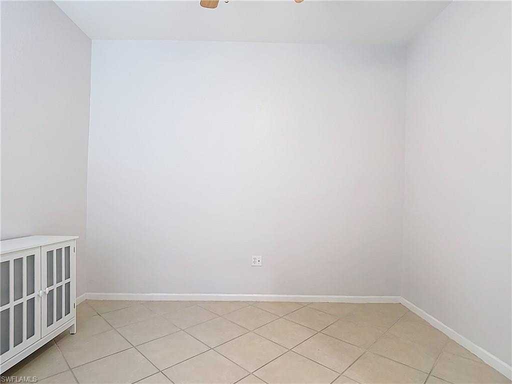 Spare room with ceiling fan and light tile patterned floors