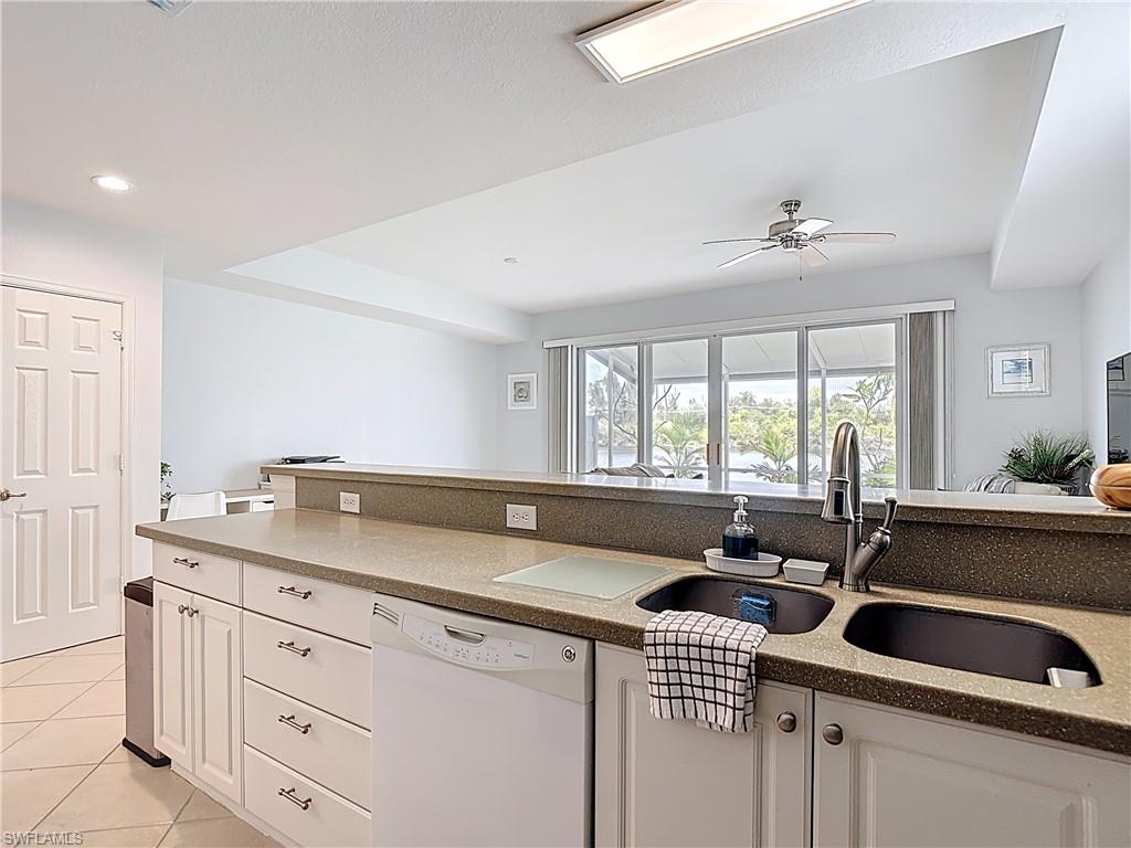 Kitchen featuring white cabinets, white dishwasher, light stone counters, light tile patterned floors, and recessed lighting