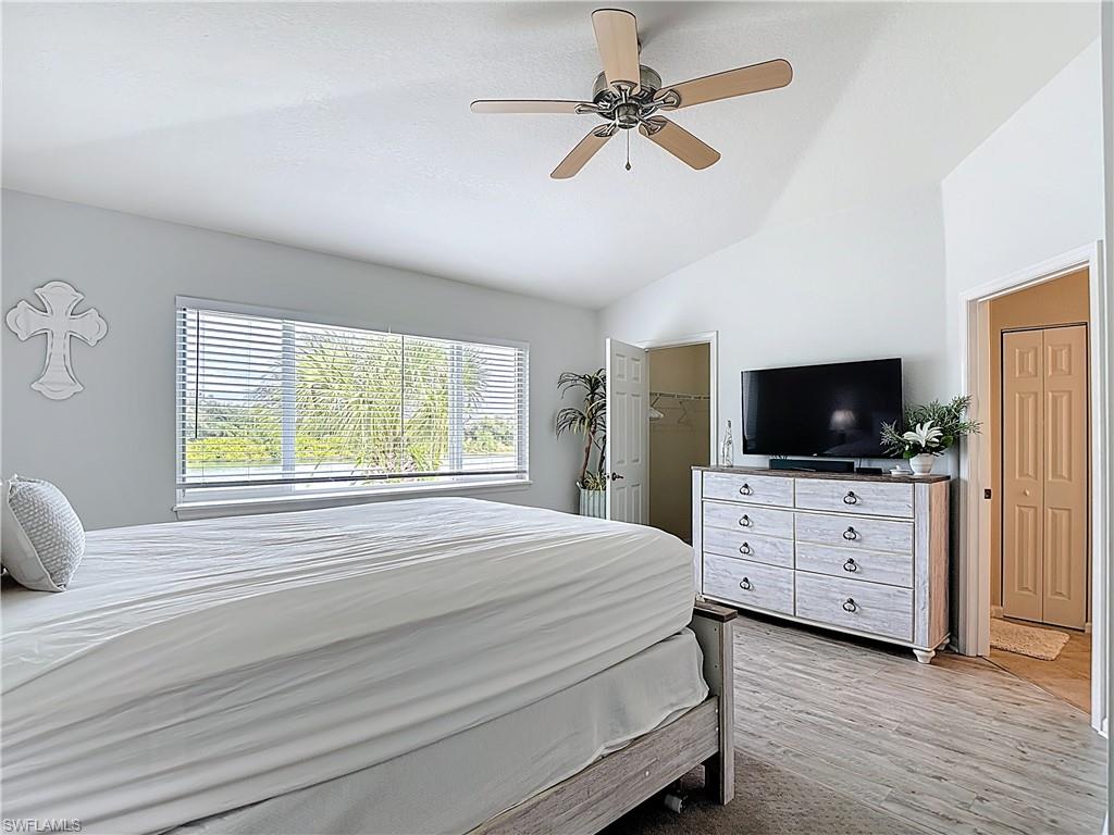 Bedroom featuring lofted ceiling, ceiling fan, light wood-style floors, and a spacious closet