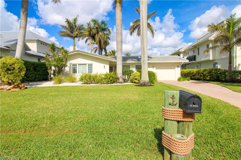 View of front of property featuring a front lawn and a garage
