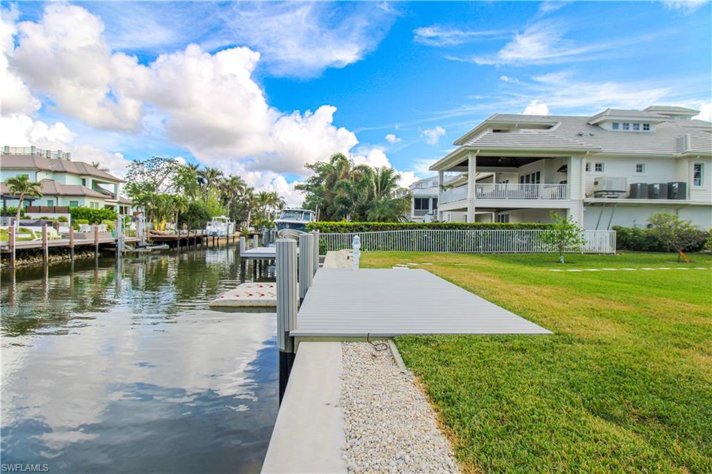 Dock area with a water view and a yard