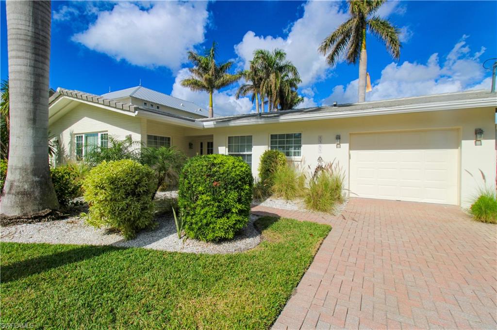 Ranch-style house with a garage and a front lawn