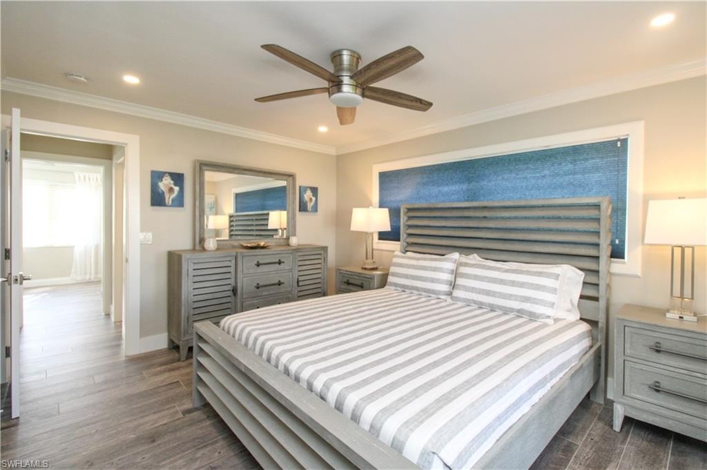 Bedroom featuring ceiling fan, dark hardwood / wood-style floors, and crown molding