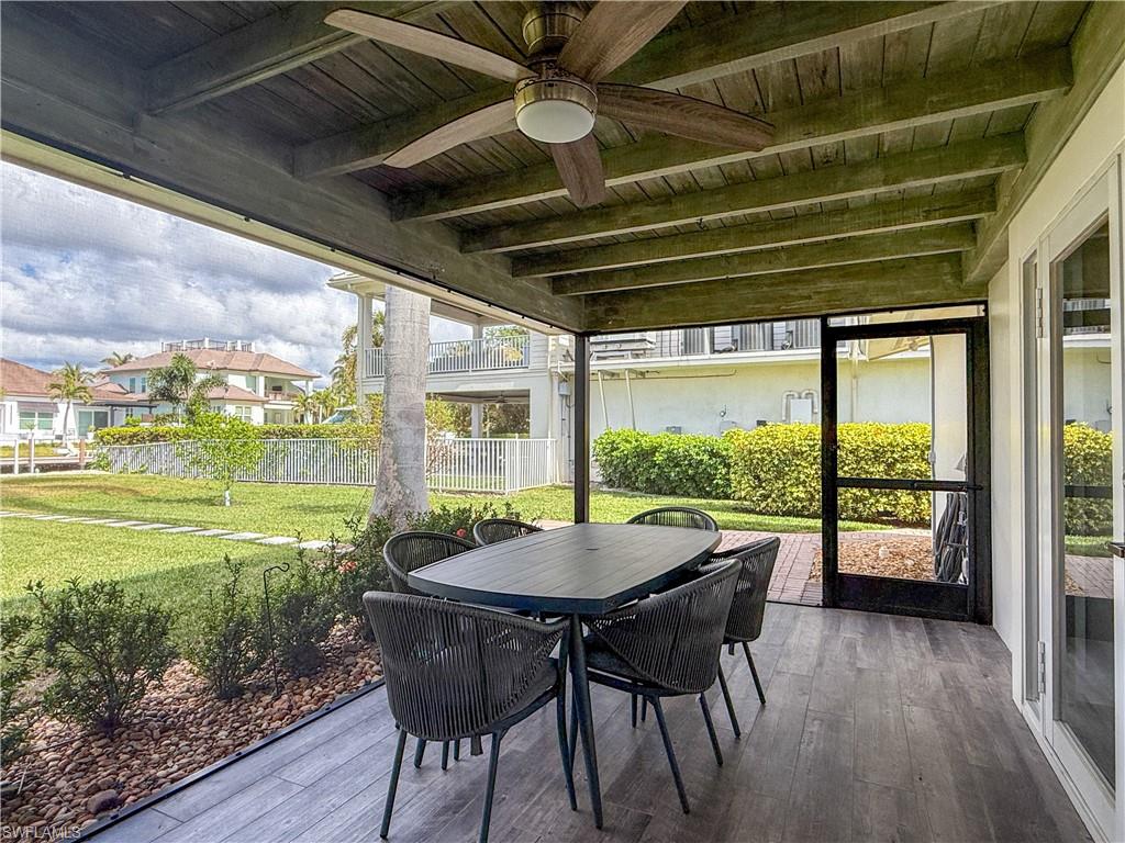 Sunroom with ceiling fan, beamed ceiling, and wood ceiling