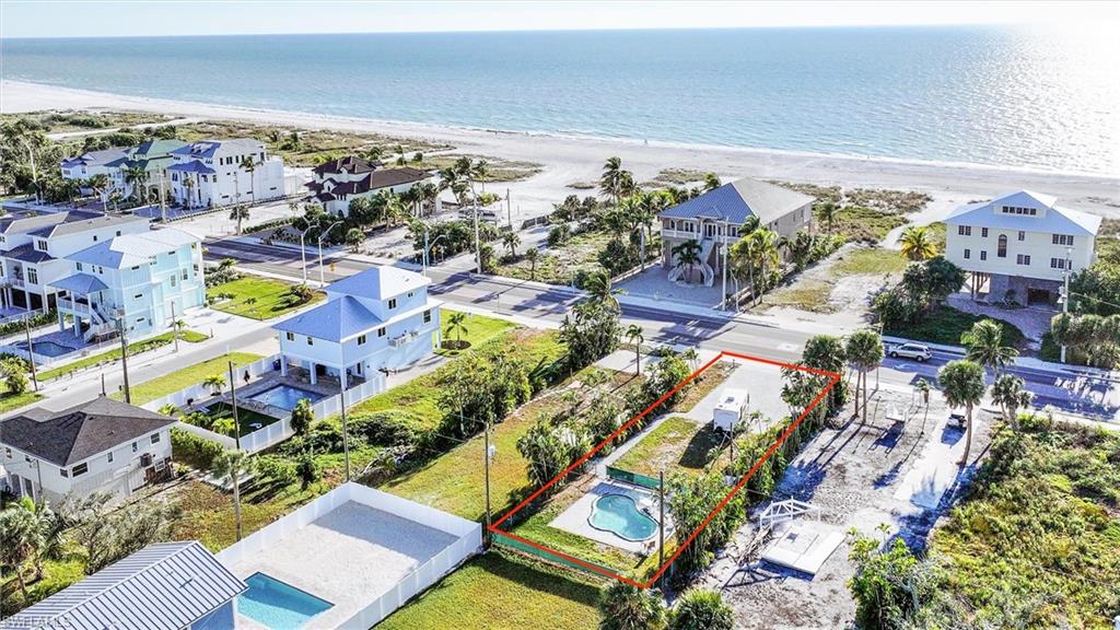 Aerial view of property and surrounding area with property parcel outlined and expansive beach