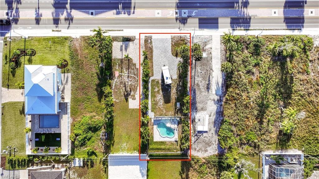 Aerial view of property and surrounding area featuring property boundaries highlighted and a pool area