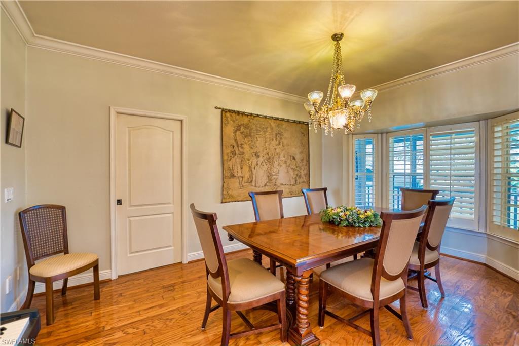 Dining room with hardwood / wood-style floors, ornamental molding, and a chandelier