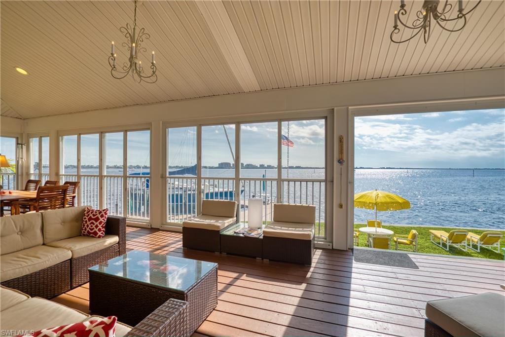 Sunroom / solarium featuring a chandelier, a water view, hardwood / wood-style floors, wooden ceiling, and lofted ceiling
