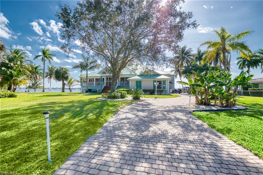 View of front of property featuring decorative driveway and a front lawn