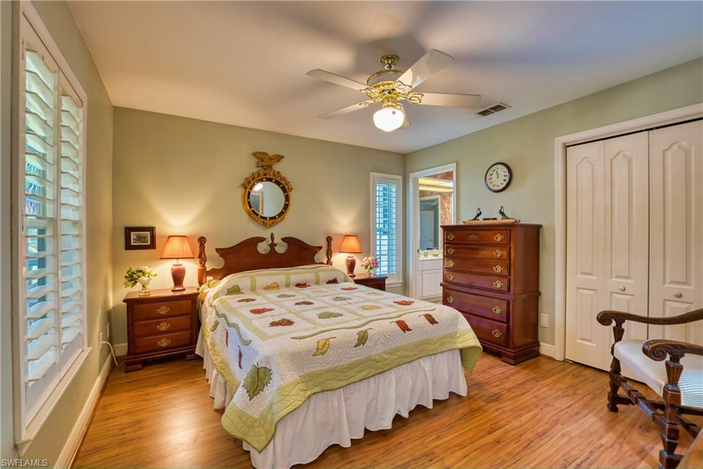 Bedroom with light wood-style floors, multiple windows, and ceiling fan