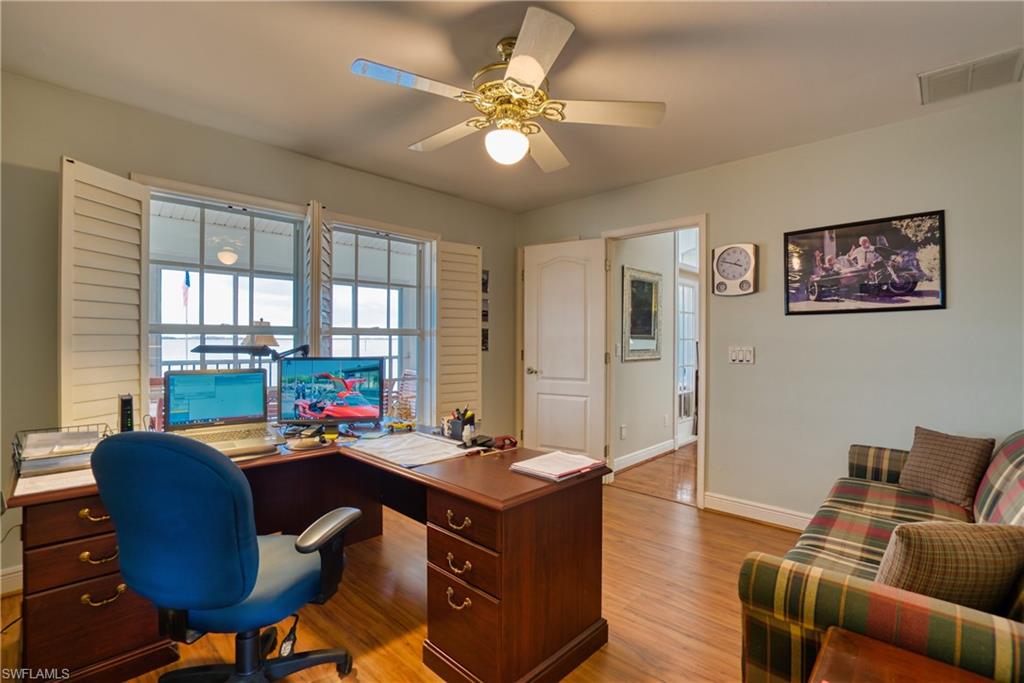 Office space with light wood-type flooring and a ceiling fan