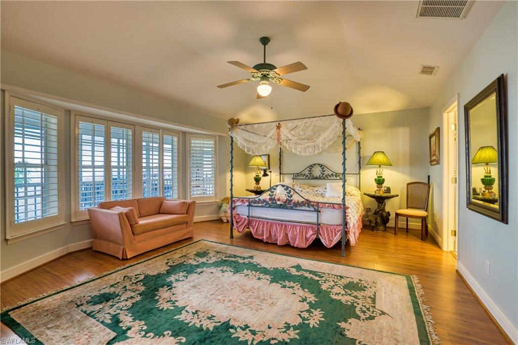 Bedroom featuring a ceiling fan, wood finished floors, and vaulted ceiling