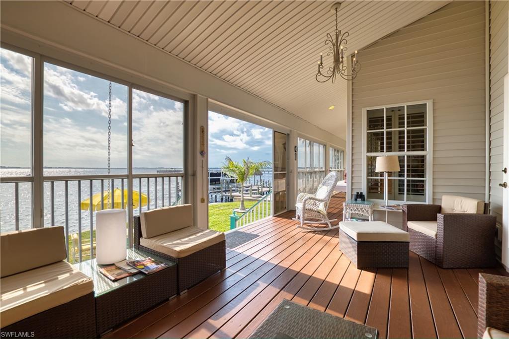 Sunroom / solarium with outdoor lounge area, vaulted ceiling, a chandelier, and a deck with water view