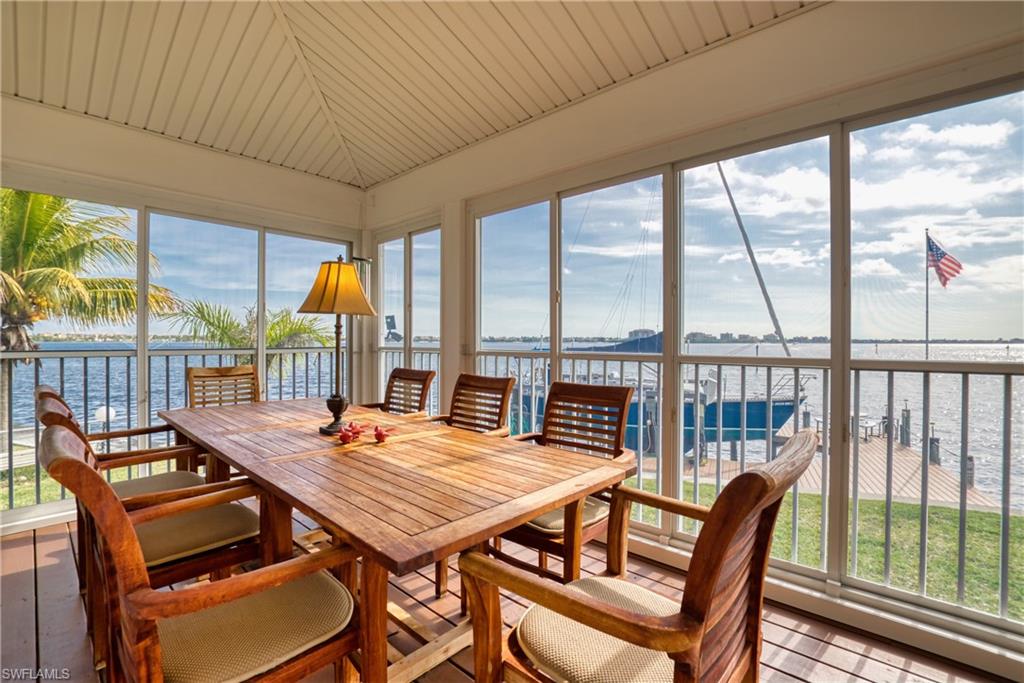 Sunroom / solarium featuring a water view, plenty of natural light, vaulted ceiling, and wood ceiling