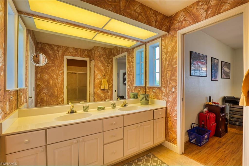 Full bath featuring double vanity and a shower with door