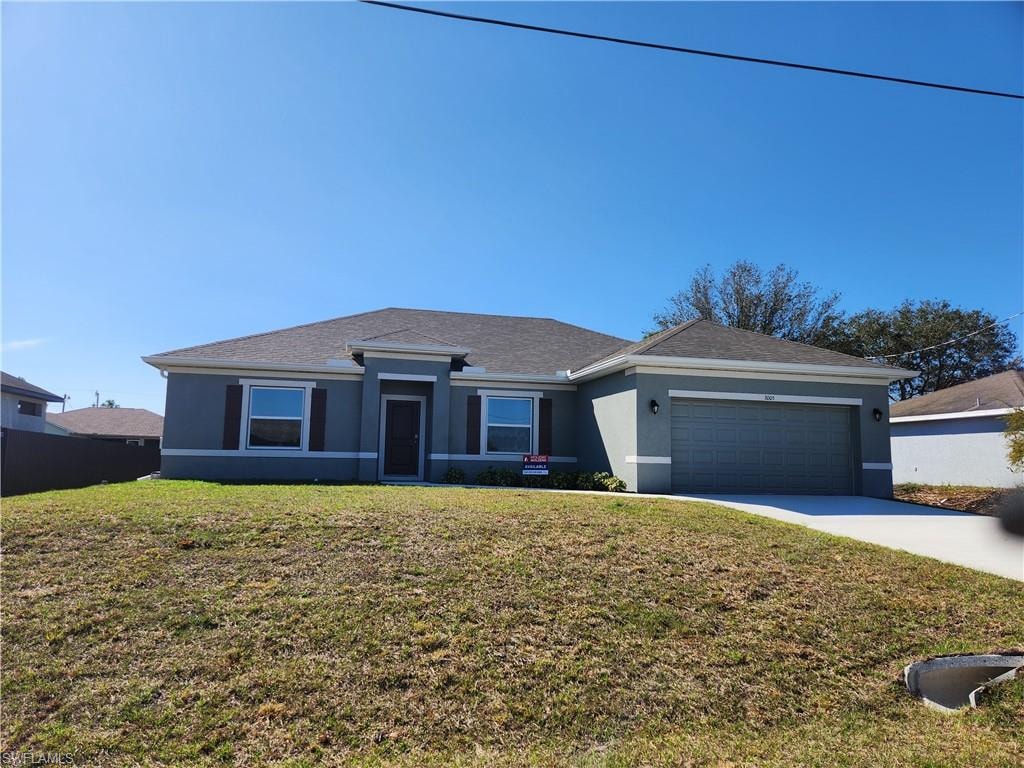 Single story home with stucco siding, a front yard, a garage, and driveway