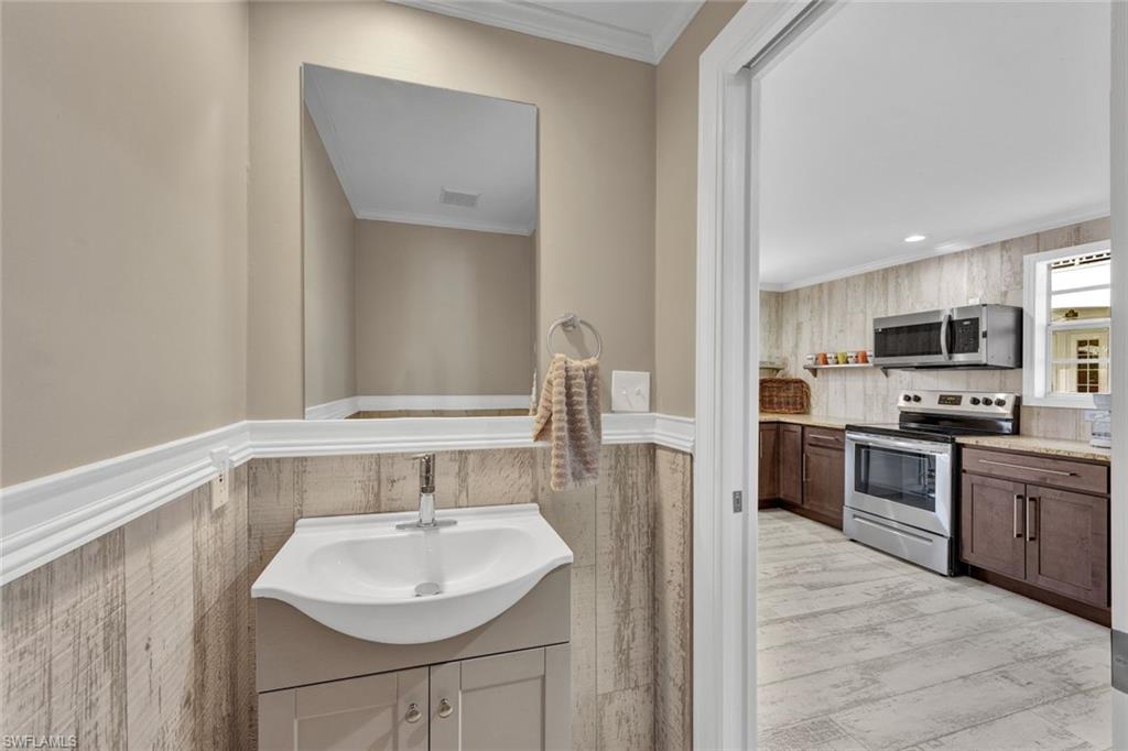 Bathroom featuring crown molding, hardwood / wood-style flooring, and sink